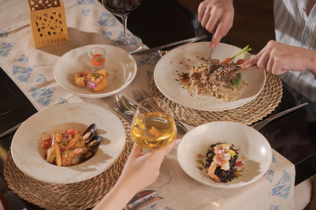 Diners enjoying a gourmet meal with wine at an elegantly set table.