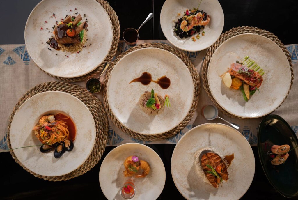 A table with an assortment of gourmet dishes artistically presented on textured plates.