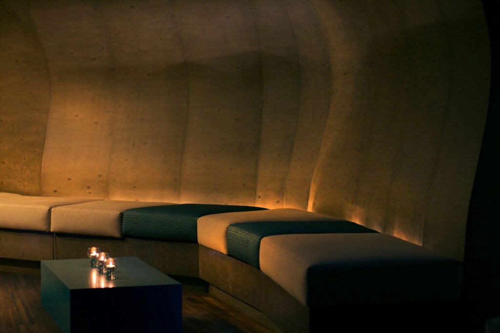 Modern lounge with curved benches and ambient lighting.