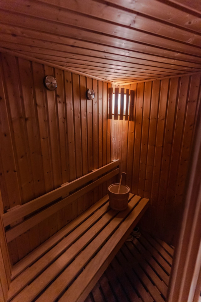 Interior of a wooden sauna room with benches and a bucket.